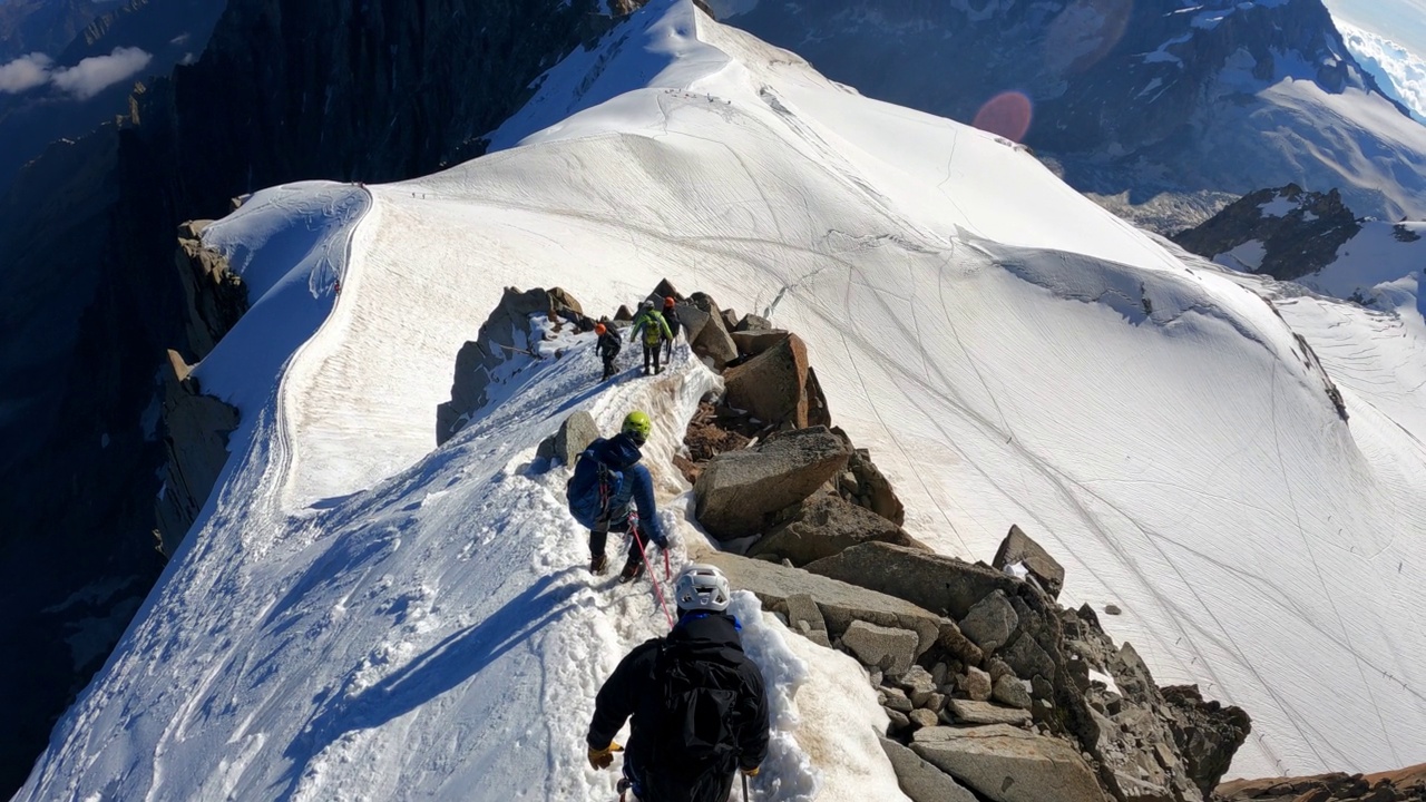 一队登山者正在攀登欧洲阿尔卑斯山的雪峰。使用绳索和攀爬设备。鸟瞰图视频素材