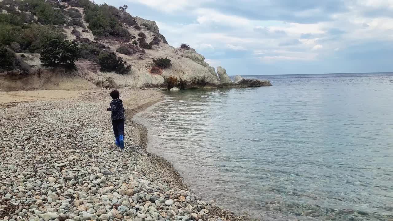 冬天的一天，一个男孩在沙滩上独自奔跑视频素材