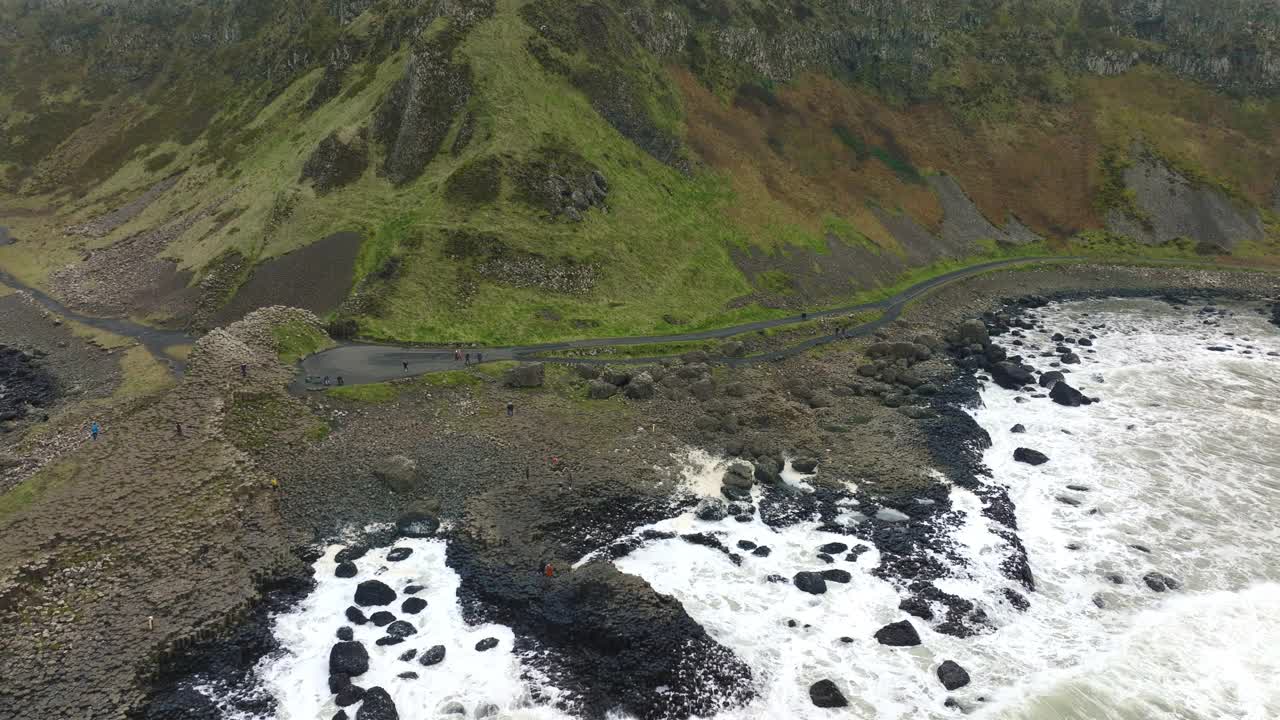 巨人的堤道无人机鸟瞰图北爱尔兰海岸跟踪从左到右海浪的岩石视频素材