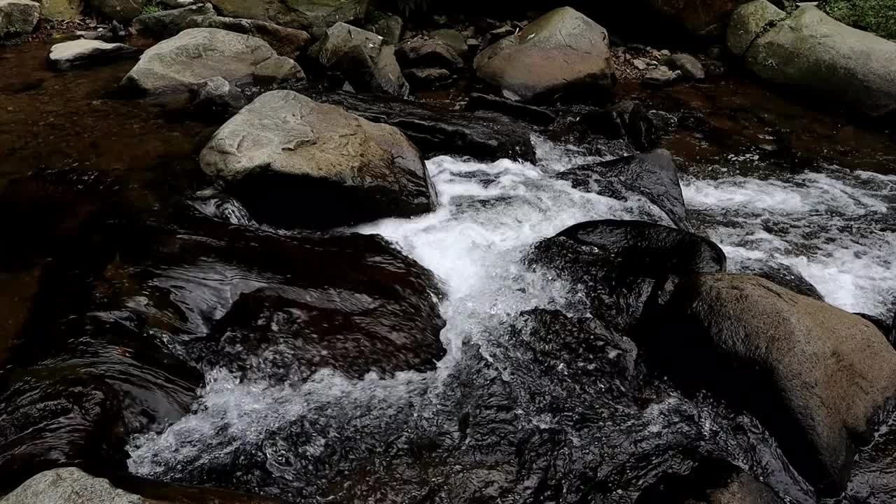 来自印度尼西亚卡拉旺的Cigentis瀑布的水流清澈干净，在岩石之间流向河流视频下载