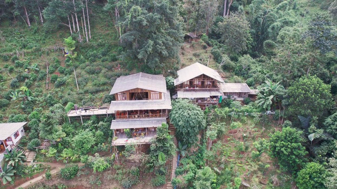 鸟瞰图，在乡村热带雨林的山谷中，传统的乡村与木制家庭住宿视频素材