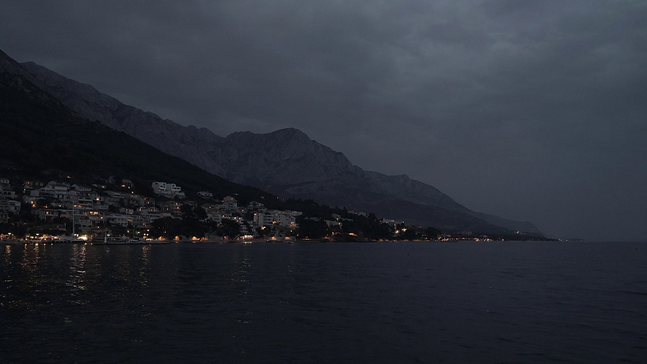 晚上从海边俯瞰城市和山脉的海岸。视频素材