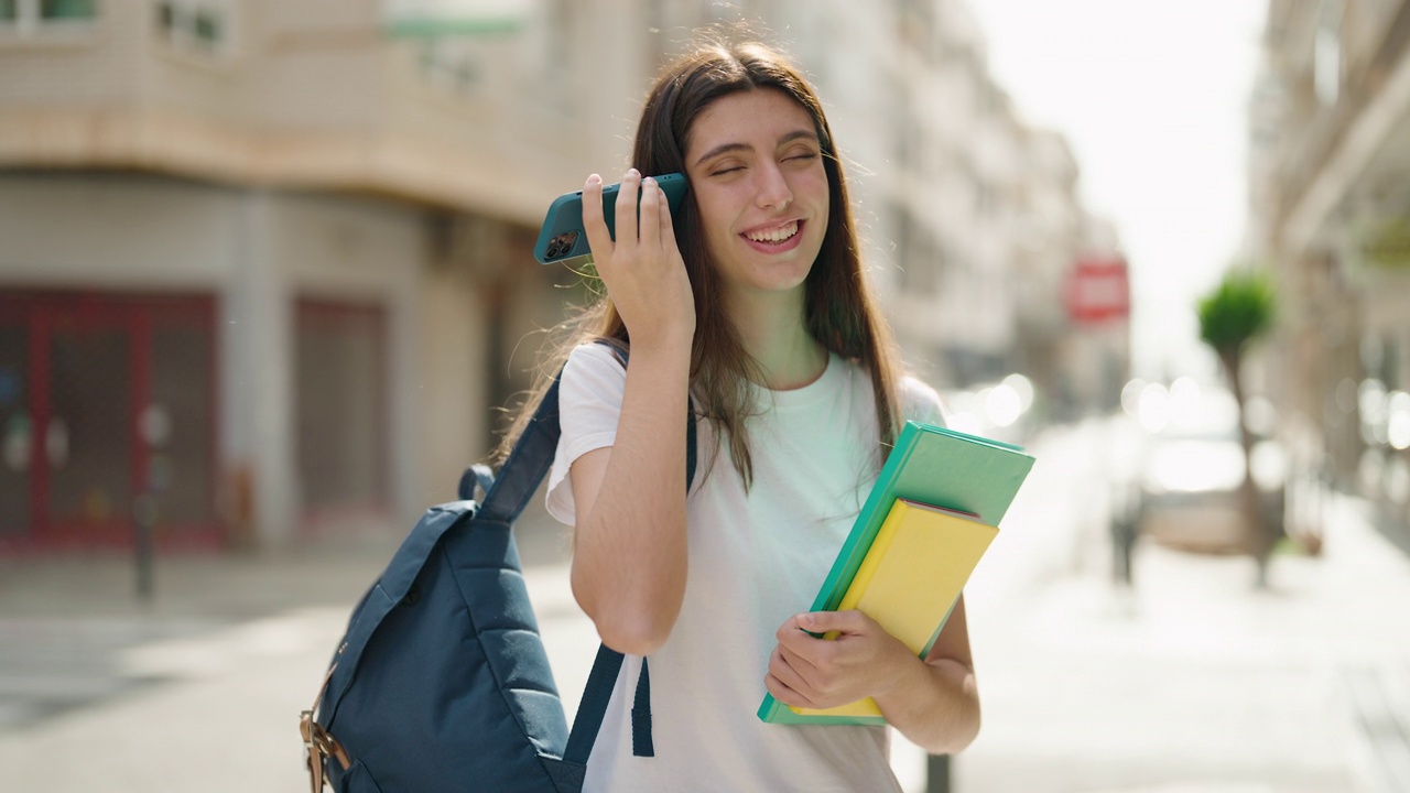 年轻的西班牙裔女学生微笑着自信地听着语音信息通过智能手机在街上视频素材