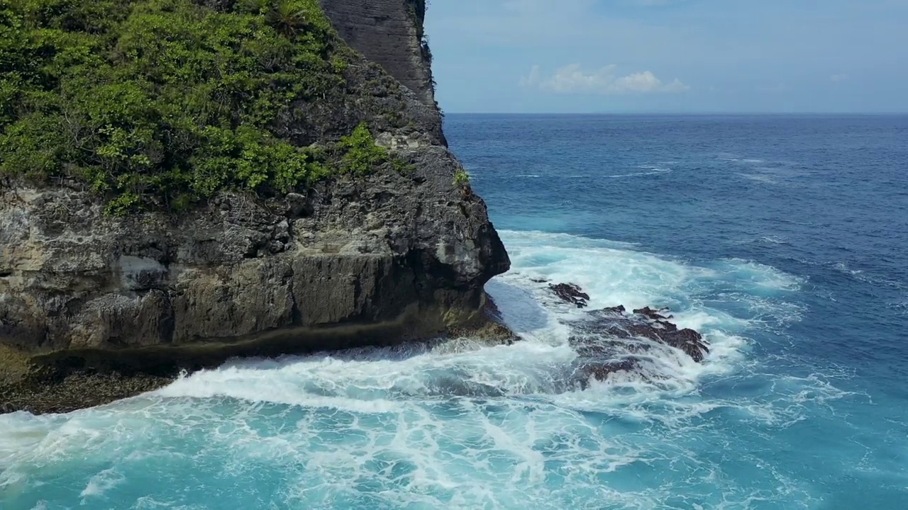 蓝绿色的海浪撞击着岩石，努沙佩尼达巴厘岛视频素材