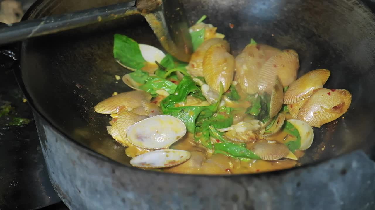 近距离烹饪泰国海鲜炒蛤蜊与烤辣椒酱在煎锅在厨房泰国餐厅视频素材