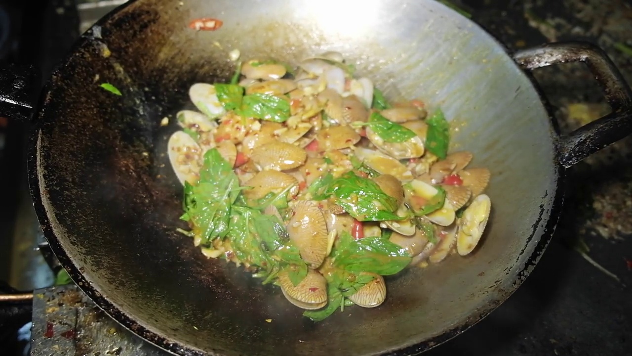 近距离烹饪泰国海鲜炒蛤蜊与烤辣椒酱在煎锅在厨房泰国餐厅视频素材