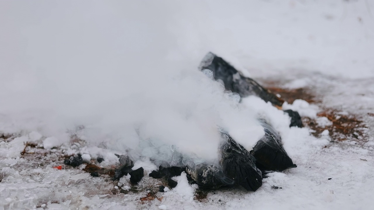 在冬天的雪地里燃起篝火。冬天的野餐。野餐后，火被雪扑灭了视频素材