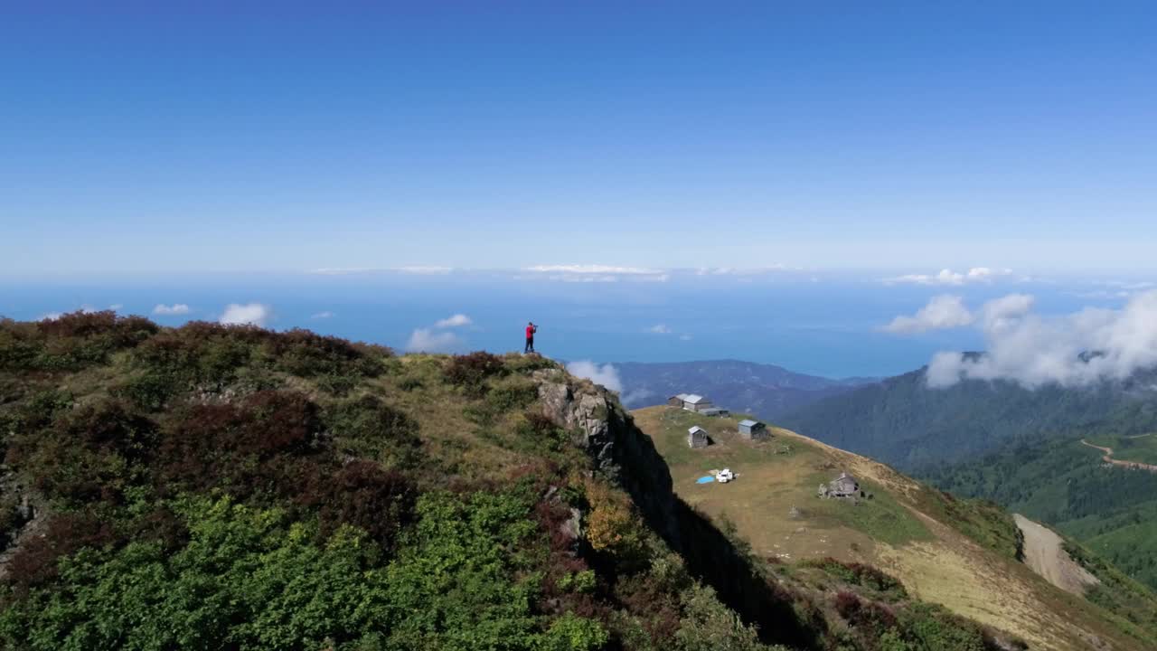 空中4K无人机拍摄的摄影师在山顶。视频素材