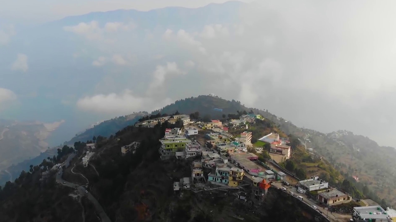 在印度北阿坎德邦的丘陵景观上的喜马拉雅城市鸟瞰图，山上有一条河流流过。无人机的观点。视频素材