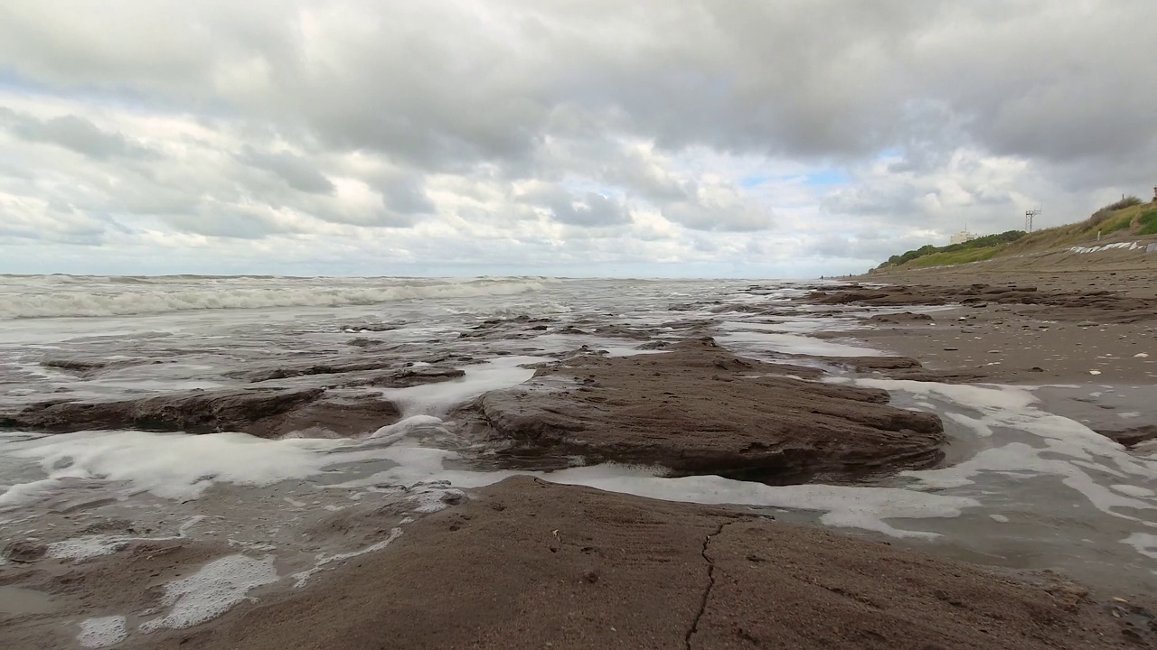 海滩上柔和的波浪拍打着岩石视频素材