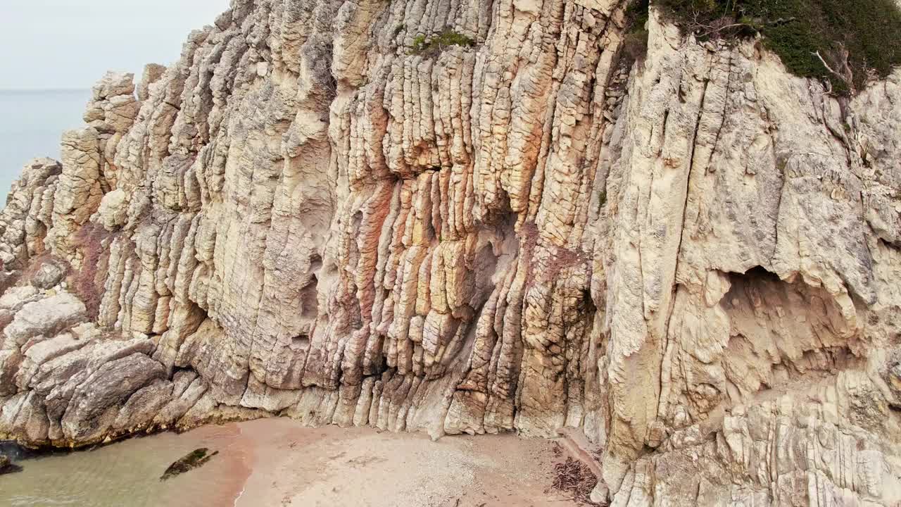 红色岩石背后平静的绿松石海视频下载