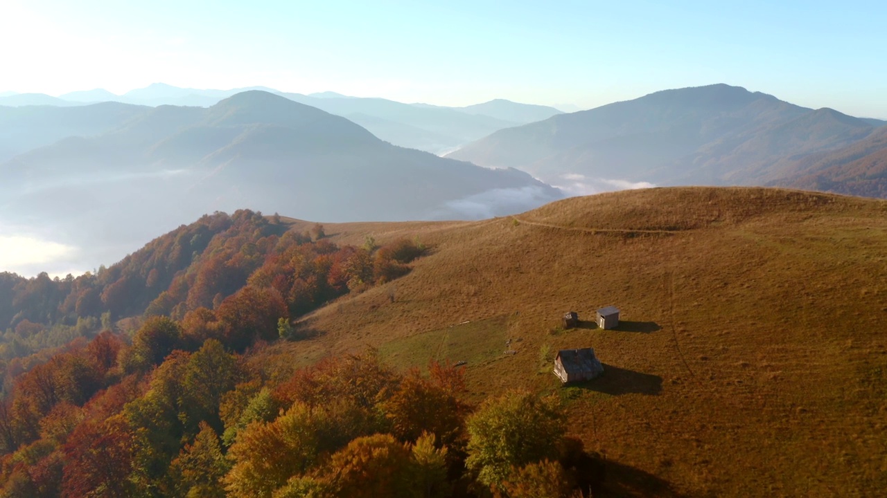 在一个阳光明媚的日子里，一架无人机飞过风景如画的秋山。视频素材