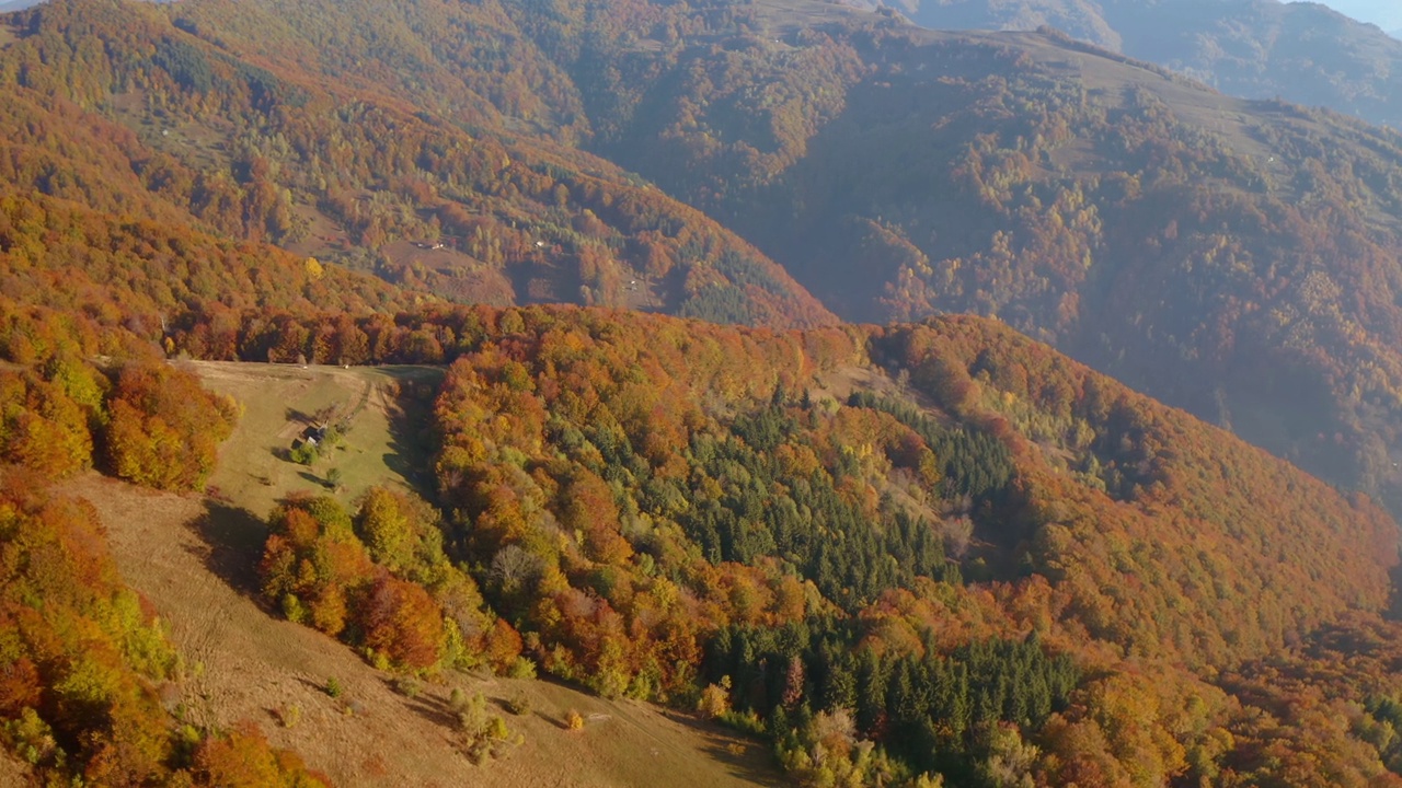 在一个阳光明媚的日子里，一架无人机飞过风景如画的秋山。视频素材