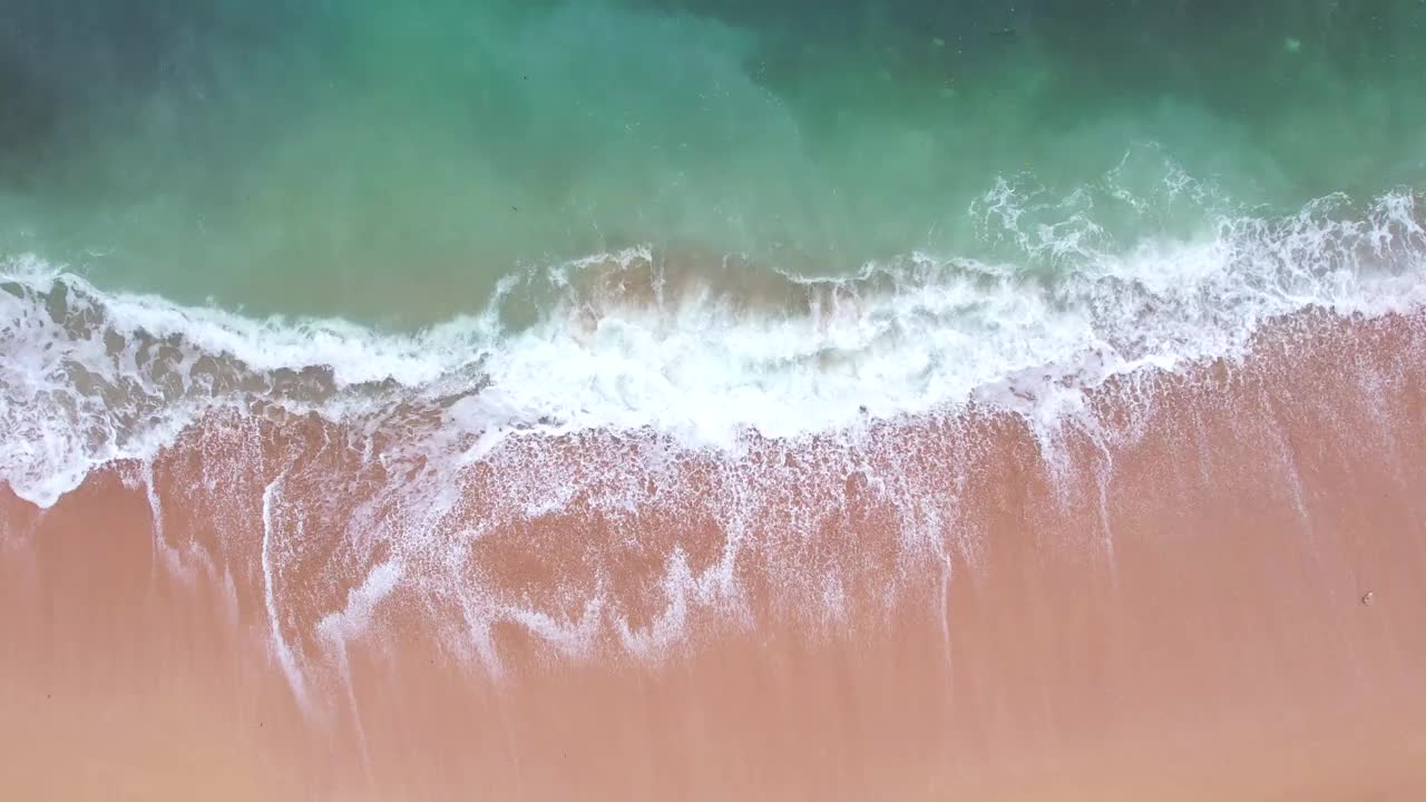 粉红色的海滩在海上掀起波浪视频素材