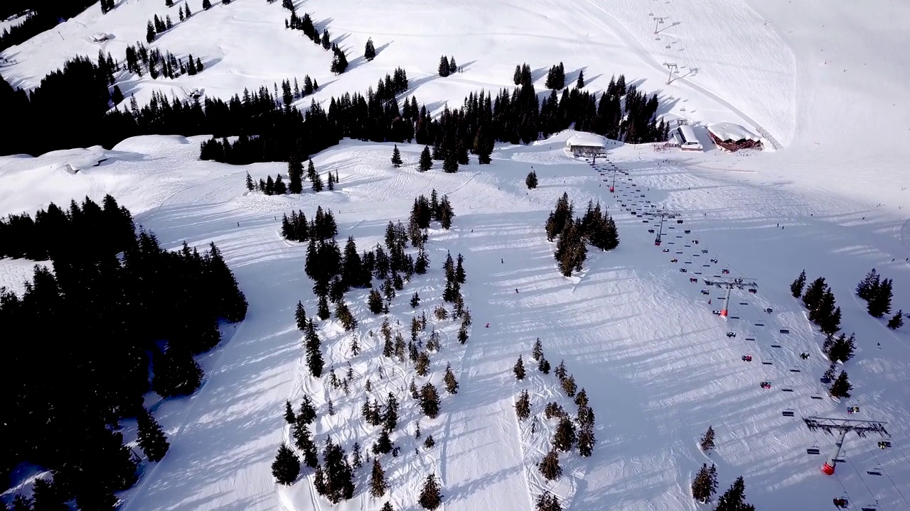 全景俯视图从无人机上的索道在滑雪胜地。滑雪电梯运送滑雪者和滑雪板在雪山滑雪场的冬季斜坡，很多人。UHD 4 k的视频视频素材