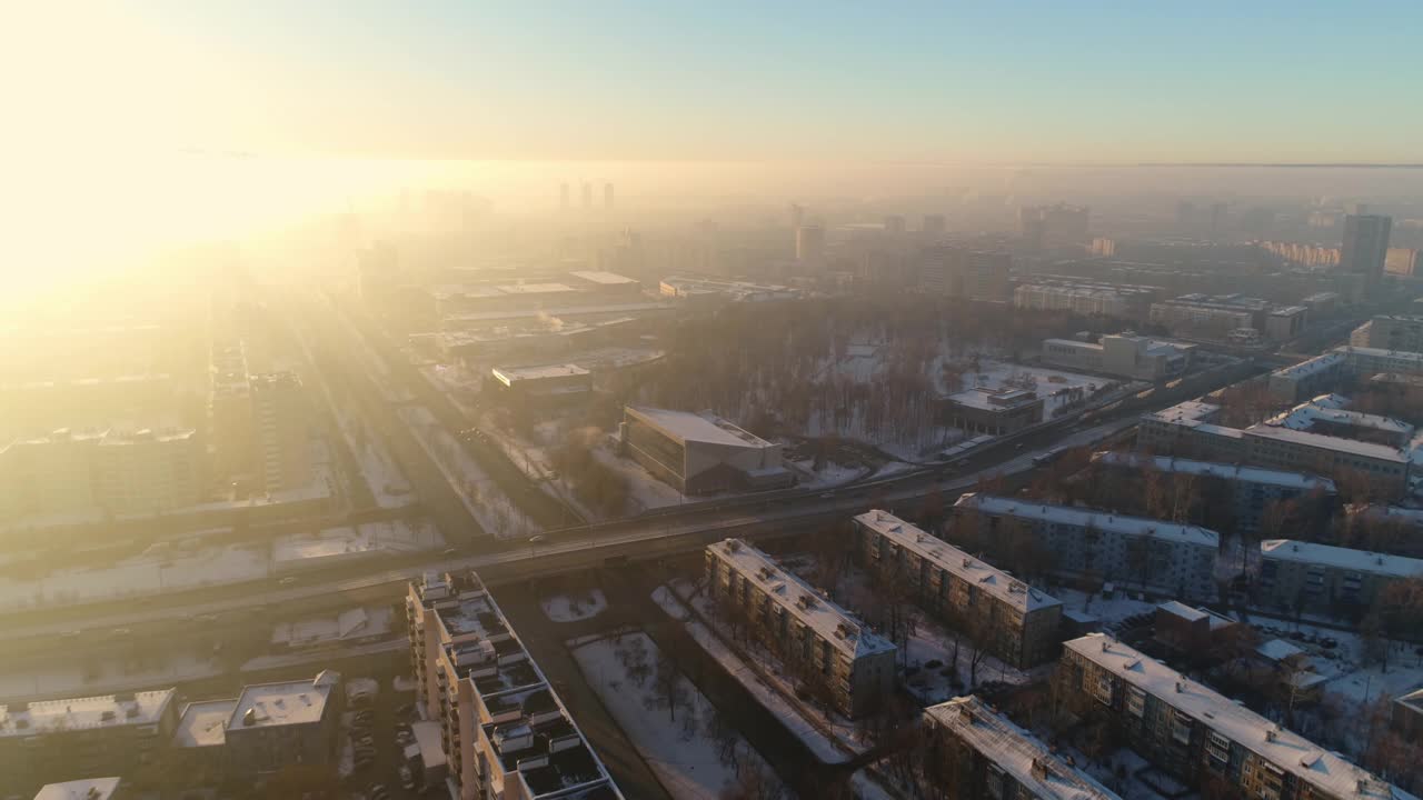 在明亮的夕阳下，蓝色的天空下，白雪覆盖的城市道路交叉视频素材