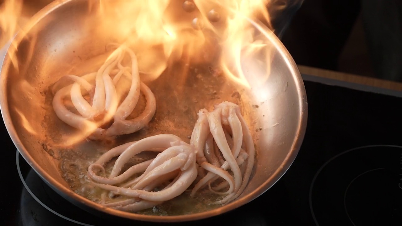 用烧油的金属煎锅准备新鲜的章鱼。视频素材