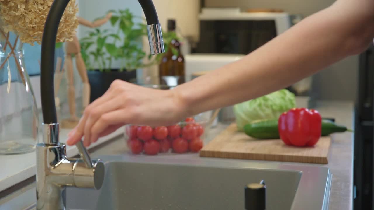 女人在厨房水槽里洗菜视频素材