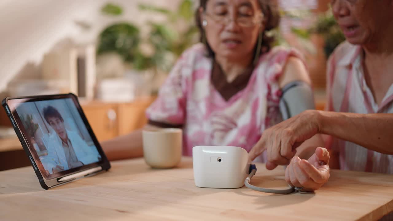 亚洲老年夫妇在家中客厅用数码平板电脑与男护士进行视频会议。科技引领健康生活方式视频素材