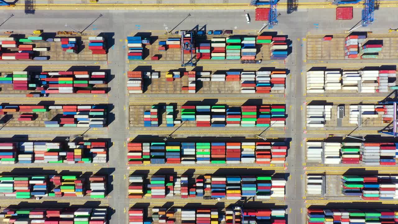 集装箱船从海港出运集装箱，有集装箱出运和集装箱仓库背景。适用于运输或进出口到全球的物流概念。视频素材