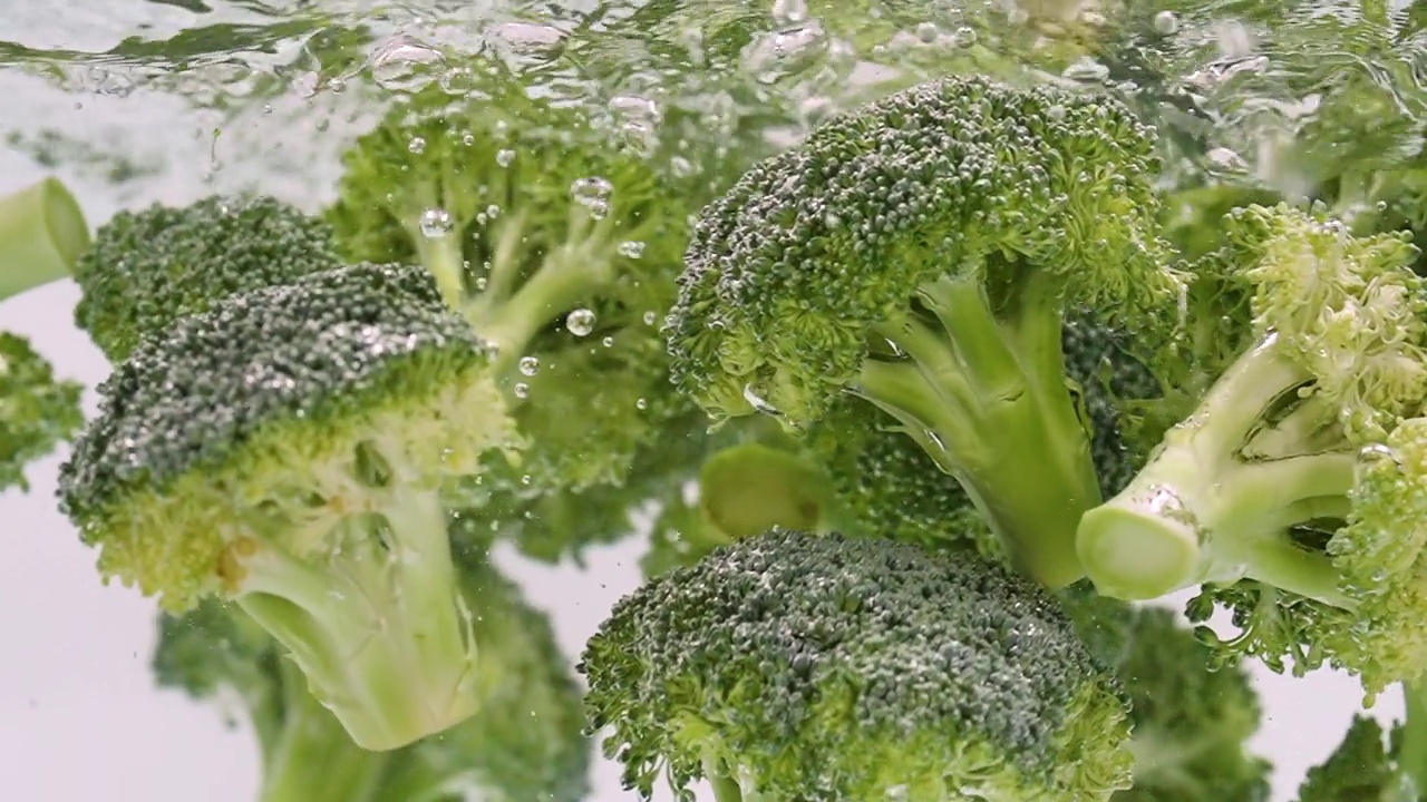 新鲜的西兰花掉进水里视频素材