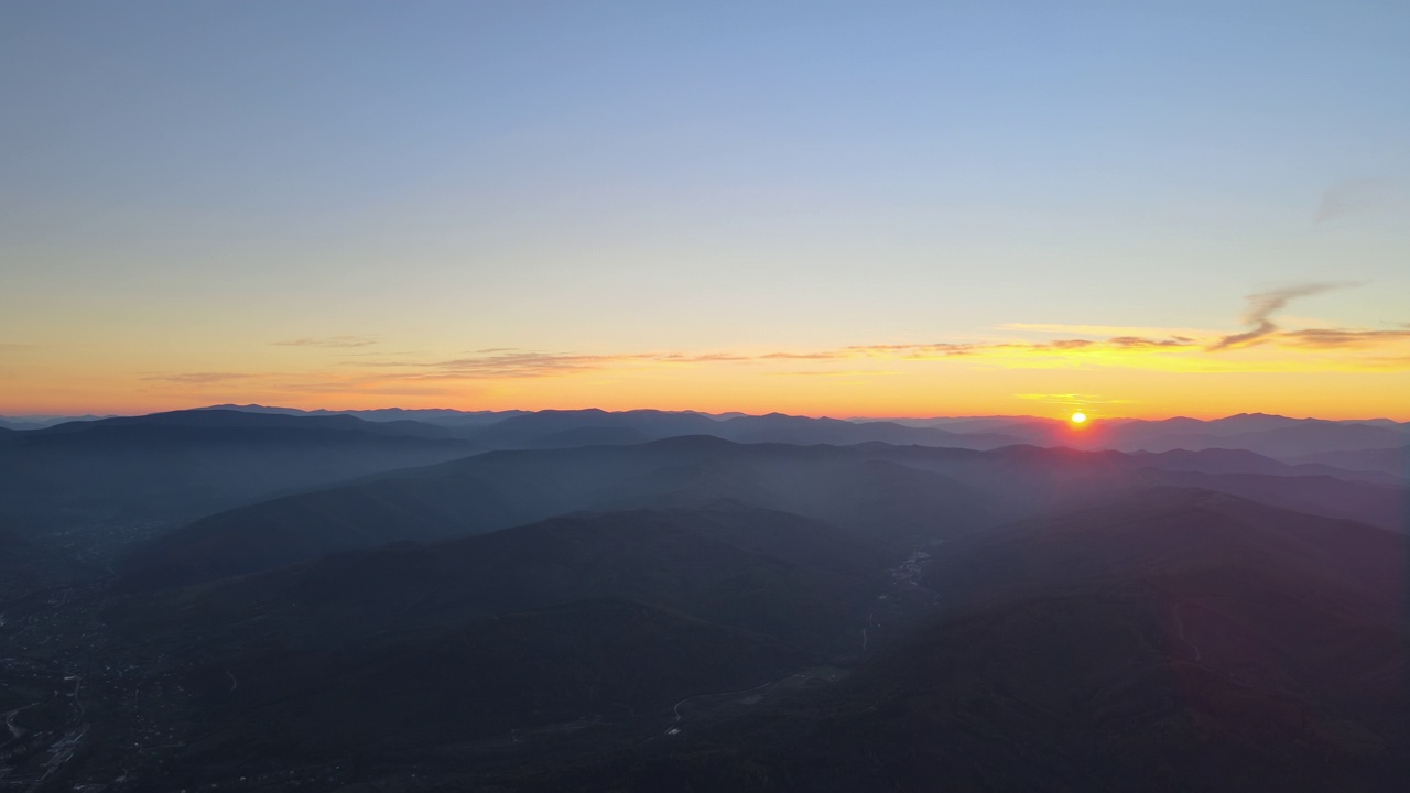 从空中俯瞰，日落时分，黑黝黝的小山和明亮的夕阳。傍晚朦胧的山峰和朦胧的山谷视频素材