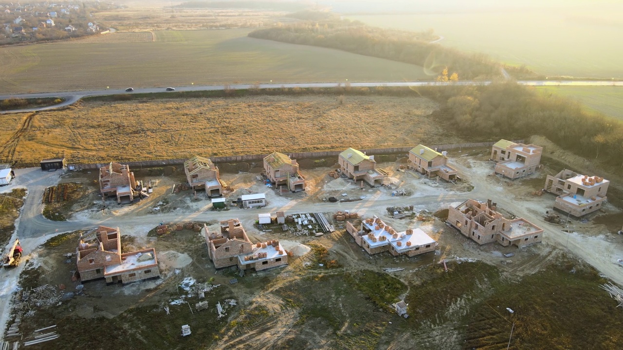 鸟瞰图的新住宅与砖框架墙建设在农村郊区。现代城市郊区房地产开发视频素材