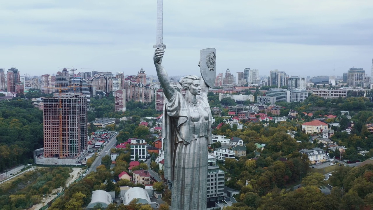 无人机在乌克兰基辅著名的史诗祖国纪念碑周围移动，俯瞰电影城市和第聂伯河全景。视频素材