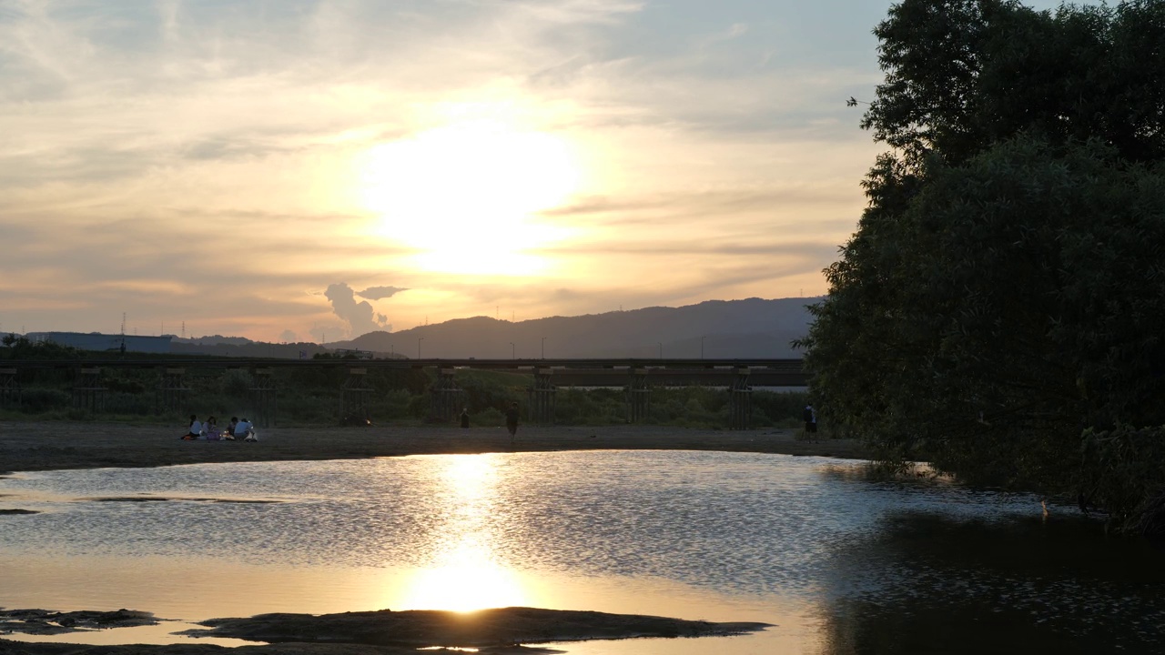 黄昏，这条河和一座古老的桥在夕阳的映照下。视频素材