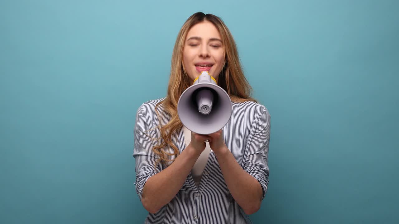 女人对着扩音器大声尖叫，做着宣告，想要被听到。视频素材