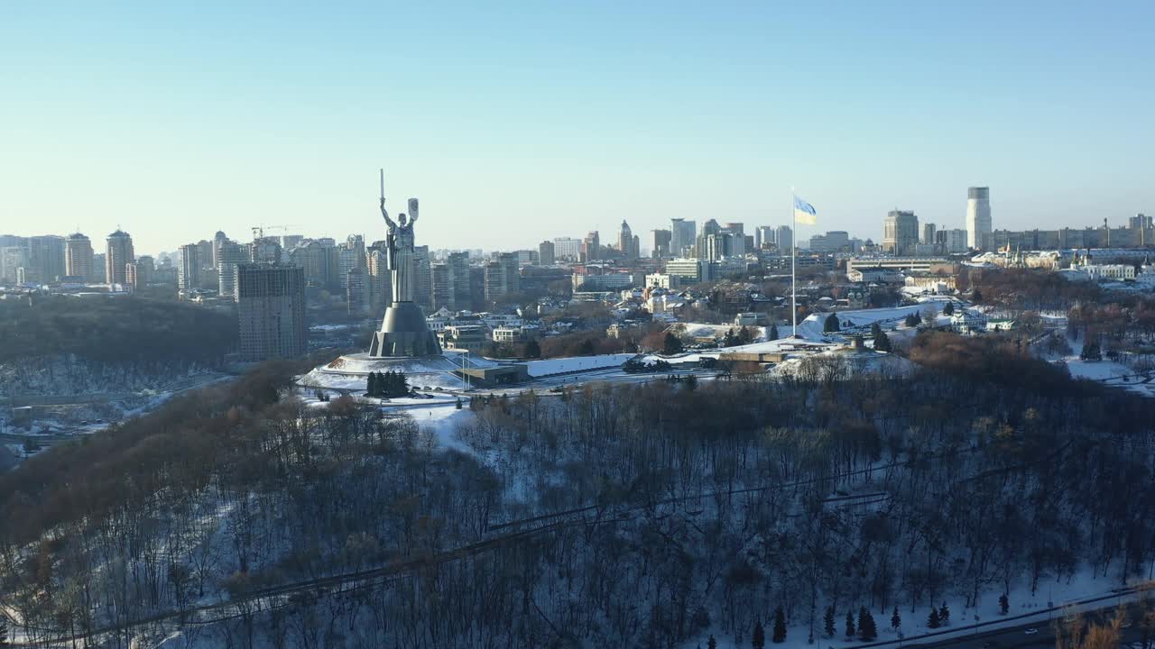 壮丽的乌克兰国旗和史诗般的祖国雕像纪念碑的空中全景在基辅在雪天晴朗的冬天。视频素材