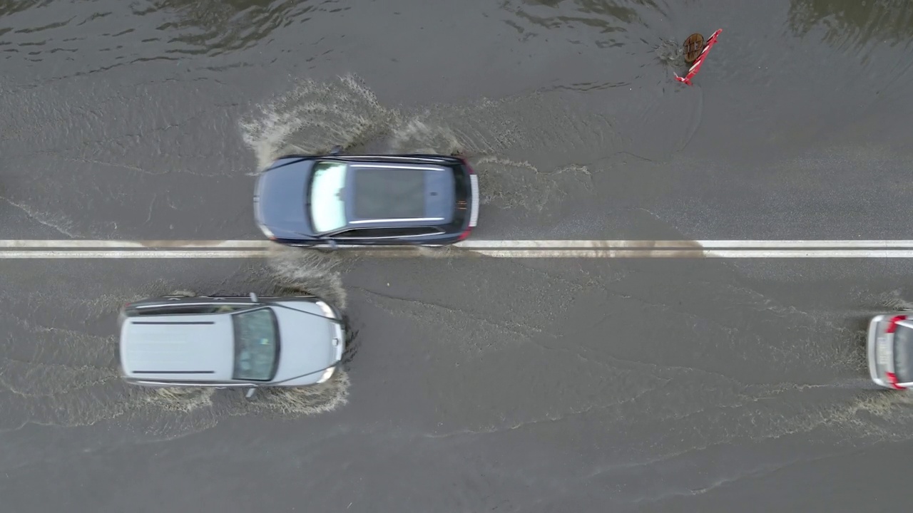 城市交通鸟瞰图，汽车行驶在暴雨后被淹没的街道上。道路排水系统的问题视频素材