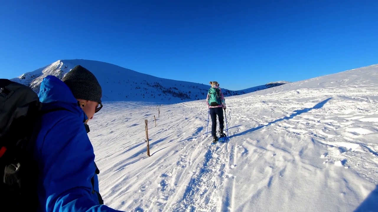 Grosser Speikkogel -一对夫妇穿着雪鞋在阿尔卑斯山的新雪中行走，Grosser Speikkogel, Styria，奥地利。视频素材