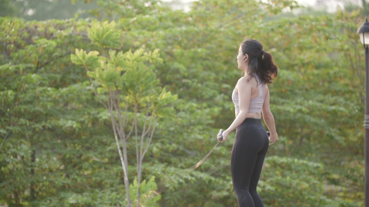 亚洲女性用跳绳练习有氧运动减肥的场景。视频素材