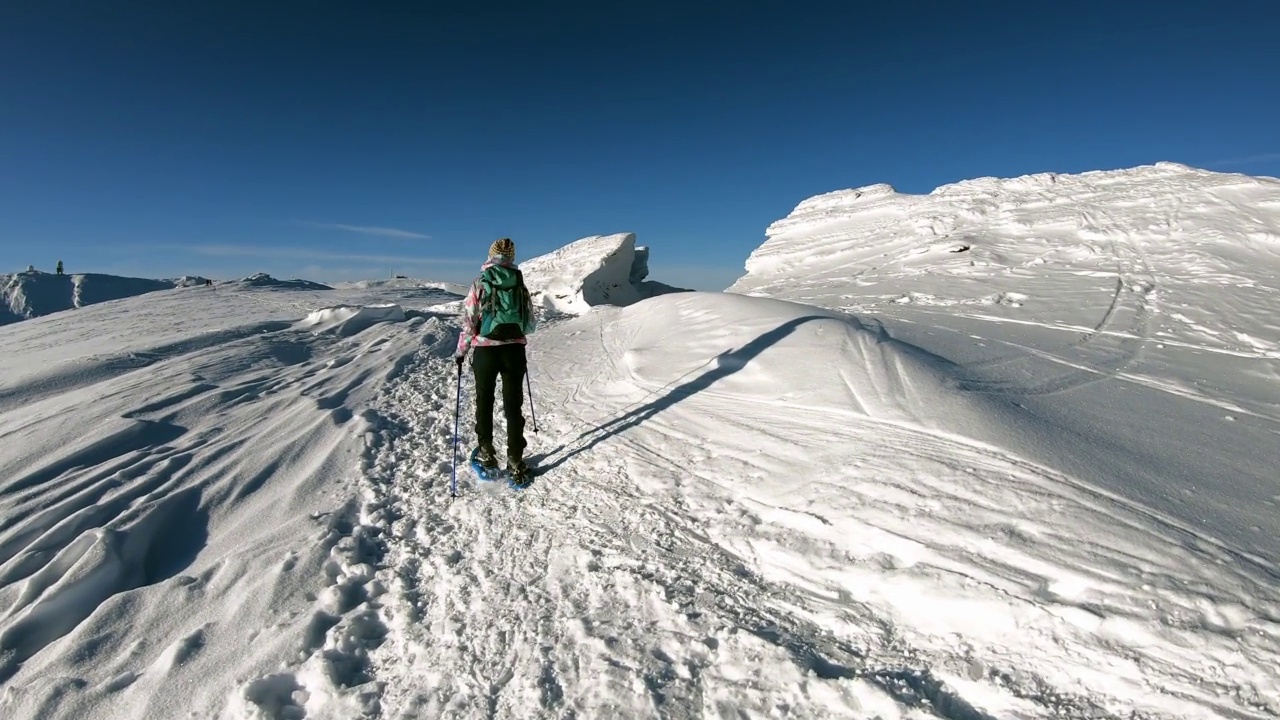 女人走在雪鞋在阿尔卑斯山的新雪，Grosser Speikkogel, Styria，奥地利。视频素材