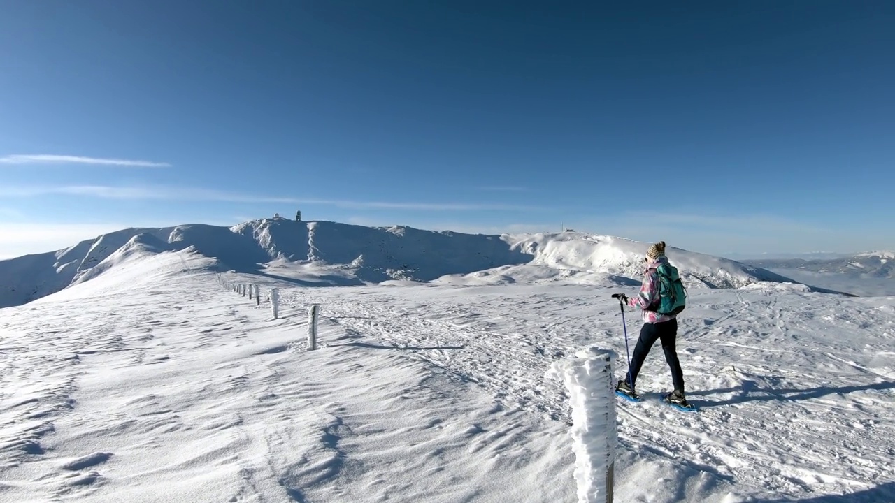 女人走在雪鞋在阿尔卑斯山的新雪，Grosser Speikkogel, Styria，奥地利。视频素材