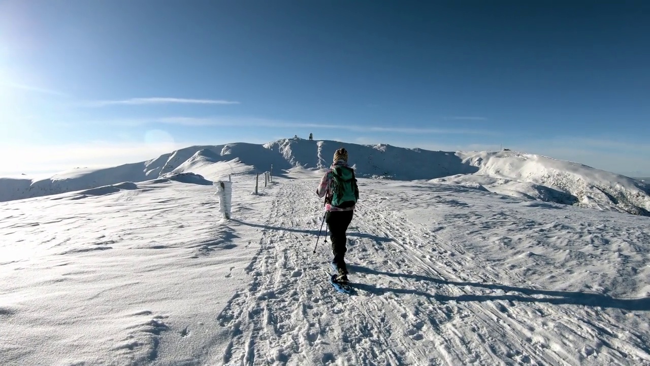 女人走在雪鞋在阿尔卑斯山的新雪，Grosser Speikkogel, Styria，奥地利。视频素材