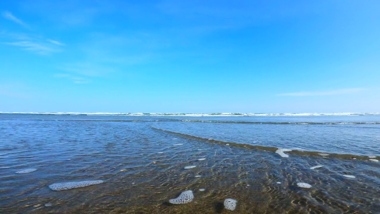 飞溅的波浪在海滩上。海浪拍打着相机视频素材