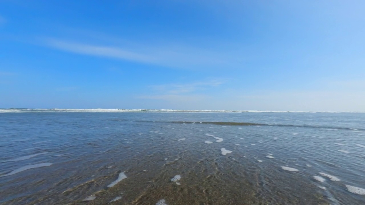 飞溅的波浪在海滩上。海浪拍打着相机视频素材