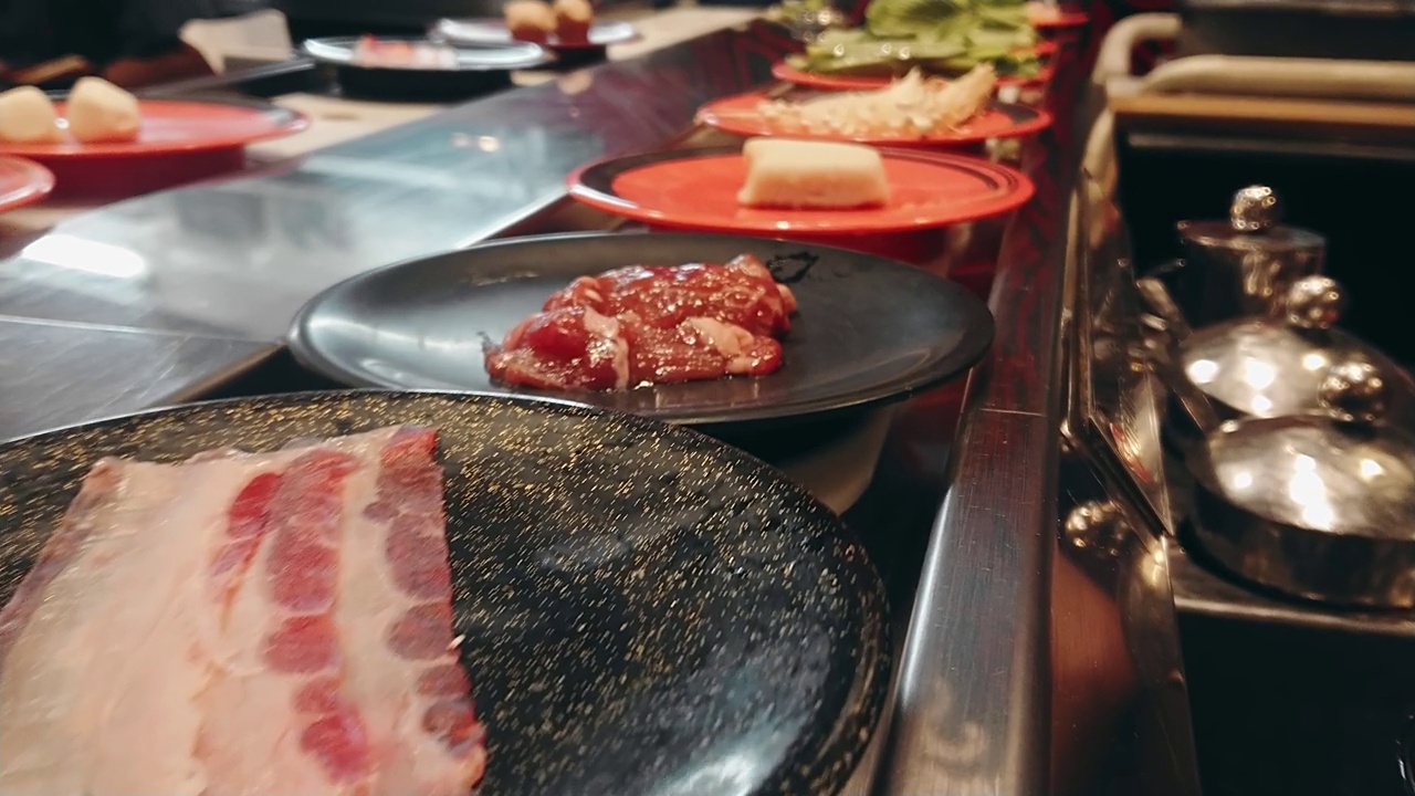 排日本食物自助餐菜皮带。日本火锅或涮锅食品输送带。视频素材