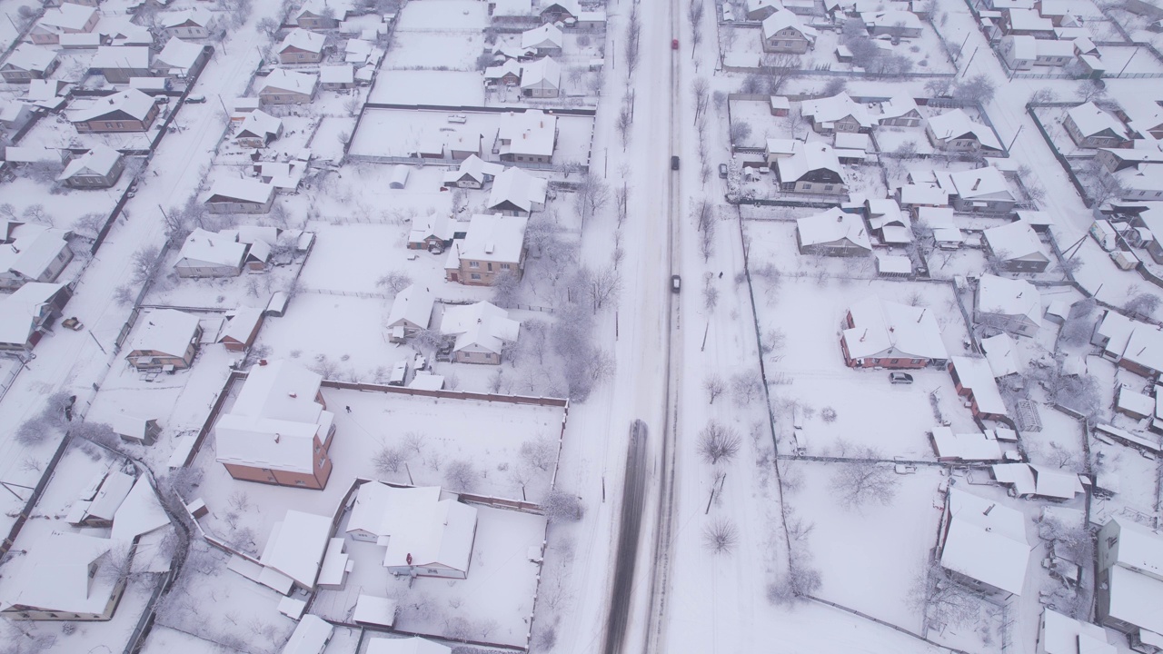 冬季鸟瞰图，雪村有私人住宅和花园地块视频素材