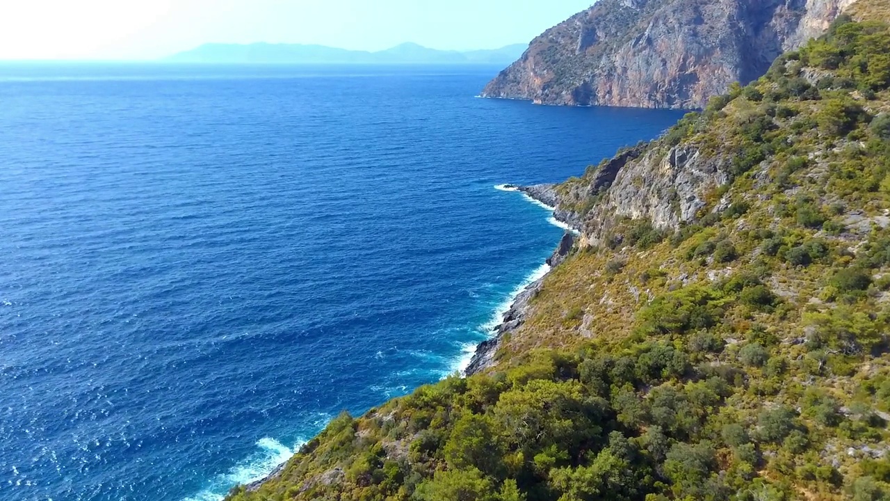 鸟瞰海岸线，悬崖峭壁，绿树成荫视频素材