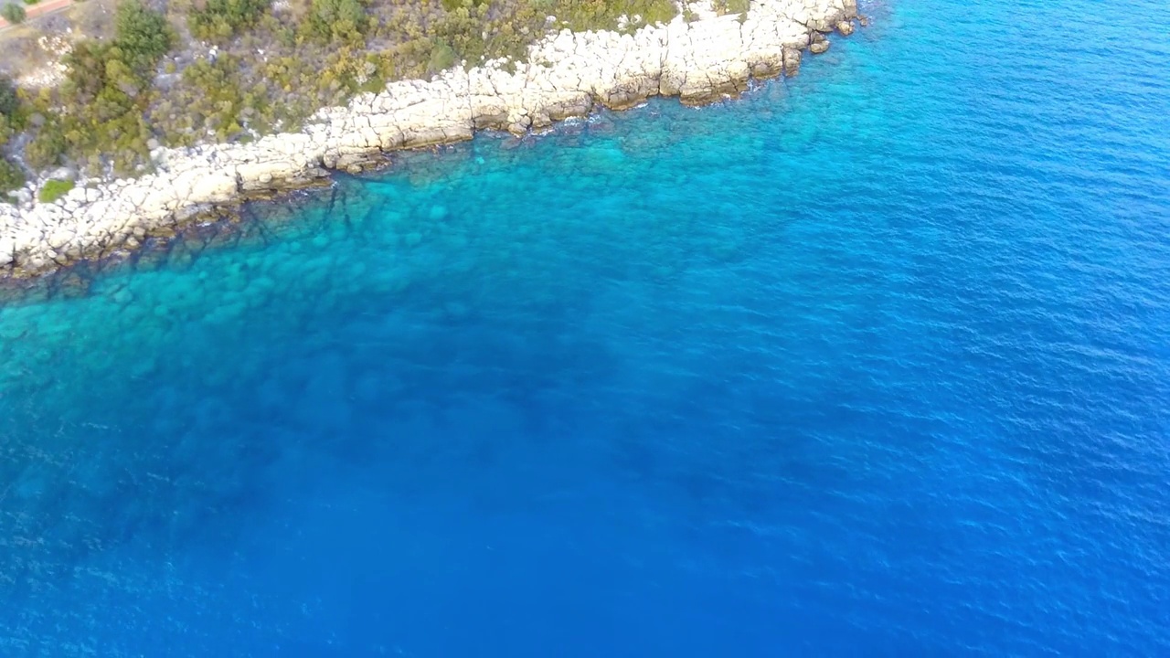 鸟瞰湛蓝碧绿的海水和岩石海岸。视频素材