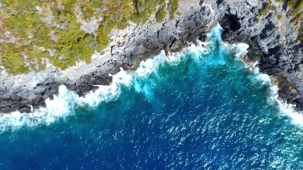 俯瞰美丽的岩石海岸粉碎泡沫海浪视频素材