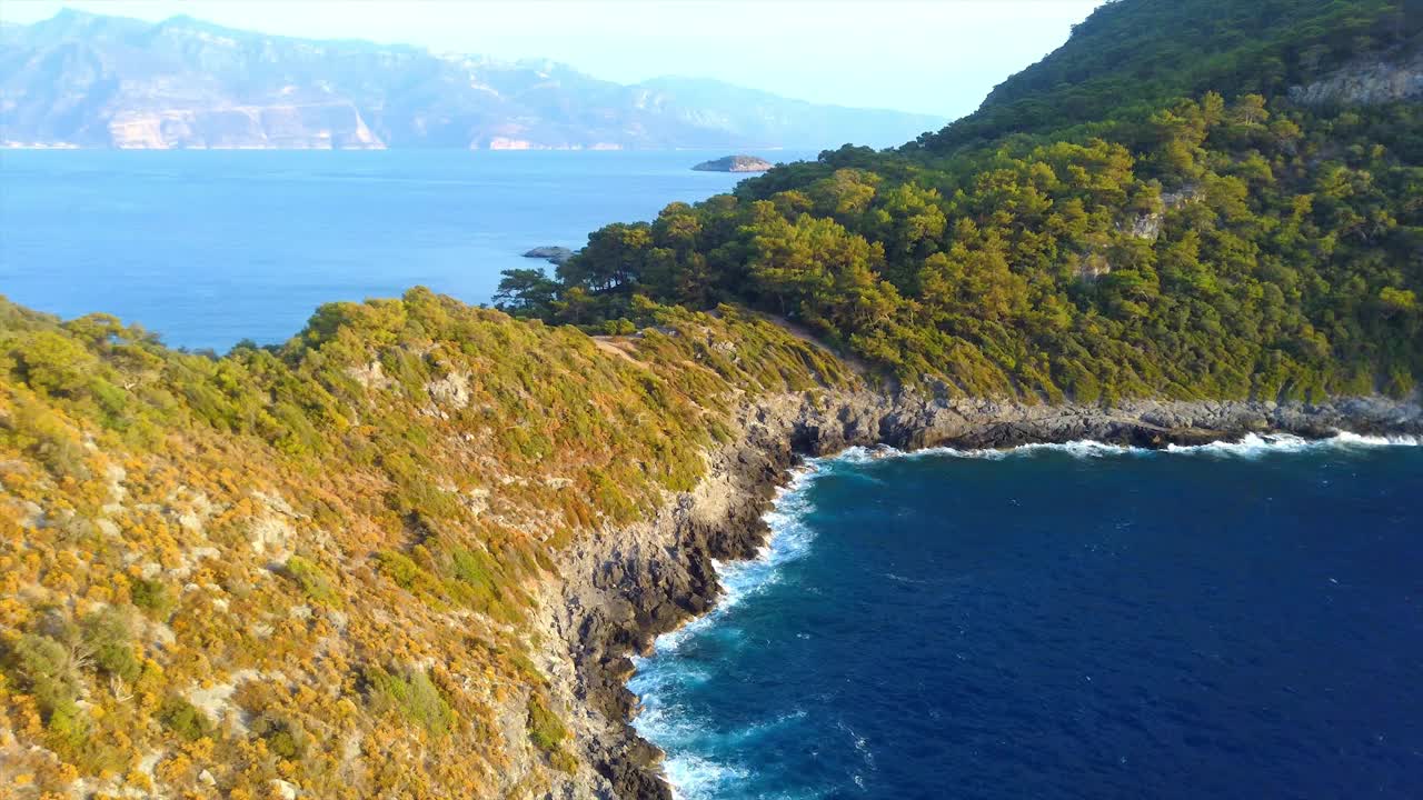 蔚蓝的海浪拍打着岩石峭壁的鸟瞰图视频素材