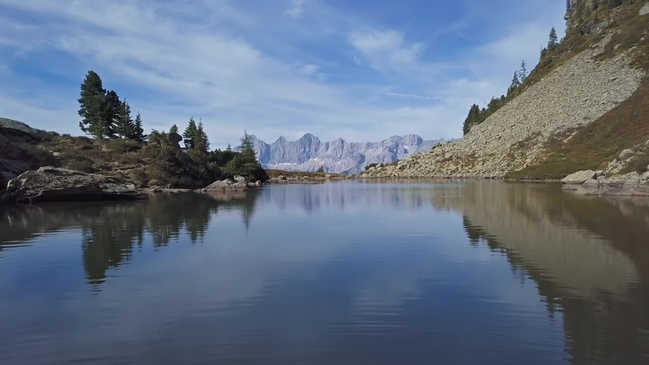 在镜湖上空低空飞行，映照着达赫斯坦山脉的倒影。Reiteralm Schladming-Dachstein,奥地利。视频素材