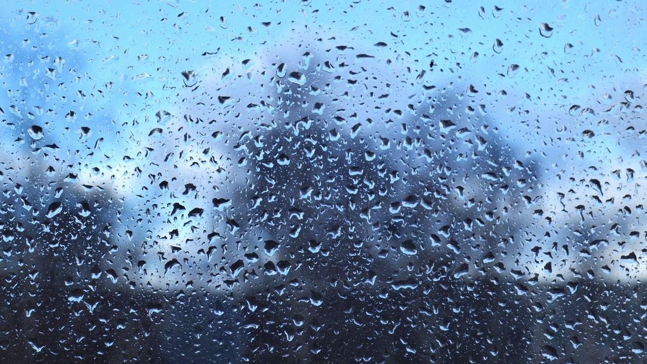 天空背景上玻璃上的雨滴特写视频素材