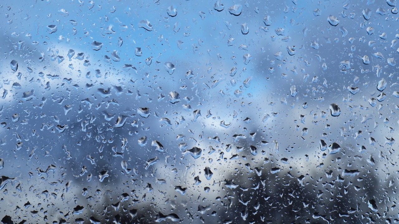 天空背景上玻璃上的雨滴特写视频素材