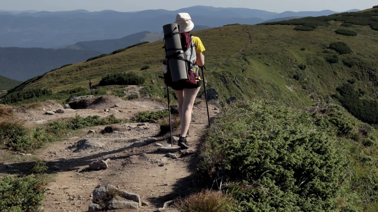 女游客走在山顶上。徒步旅行的人享受生活，风景秀丽，自然风光。暑假探险旅行。背包客徒步旅行高山夏季徒步旅行视频素材