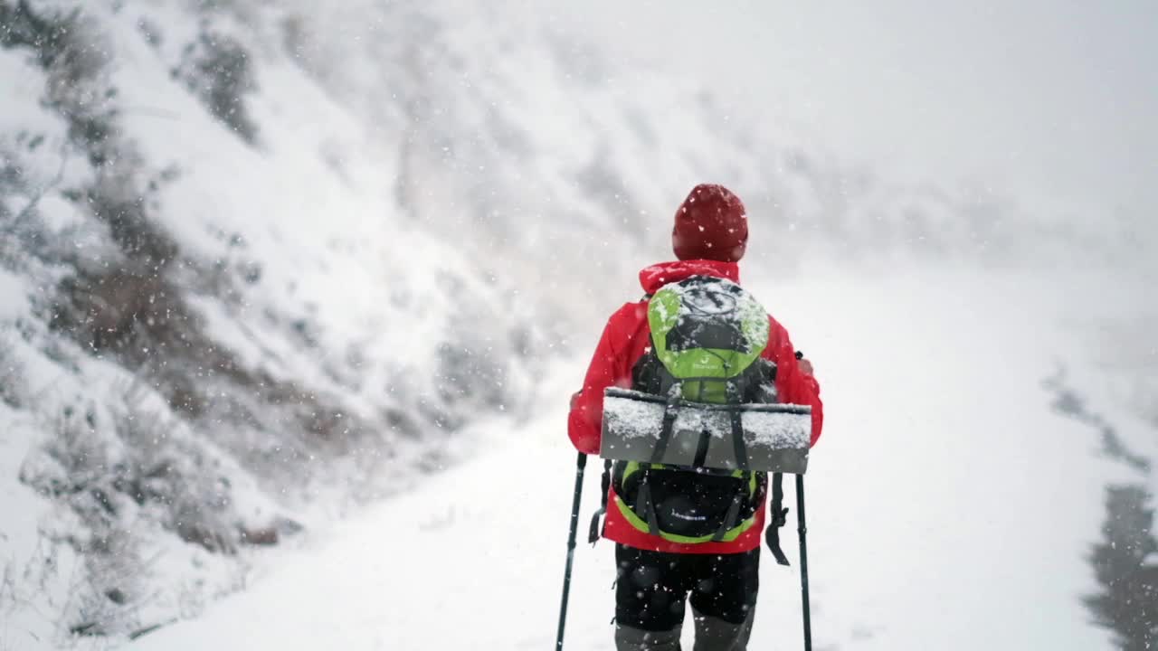 冬天背着背包在山里徒步旅行的人视频素材